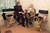Ian McKellen i Patrick Stewart sjede u redateljskim stolicama i razgovaraju tijekom promocije filma X-Men.