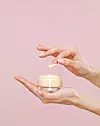 female hands, glass make up container, foundation, finger with make up on, make up, pink background