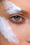 Extreme close-up of woman with cream on her face