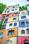 Hundertwasser krase šarena pročelja, zakrivljene linije i stabla na krovovima