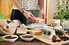 Woman cutting handmade soap in pieces and packing it for customers
