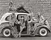 circa 1968: Young men and women pose in and on a car while modeling factory-made versions of Flower Power clothing, England. (Photo by Brian Duff/Daily Express/Express/Getty Images)