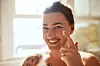 Shot of an attractive young woman applying moisturiser during her morning beauty routine
