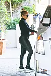 West Hollywood, CA - Jennifer Lopez leaves the Sunset Towers hotel alongside a friend in Hollywood. The songstress dons an all-black ensemble with her satin workout pants standing out the most. J-Lo carries with her her signature bedazzled