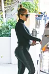 West Hollywood, CA - Jennifer Lopez leaves the Sunset Towers hotel alongside a friend in Hollywood. The songstress dons an all-black ensemble with her satin workout pants standing out the most. J-Lo carries with her her signature bedazzled